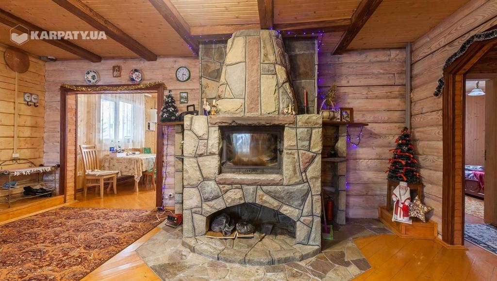 sala de estar con chimenea de piedra y TV en У Гриніва, en Polyanitsa Popovichovska