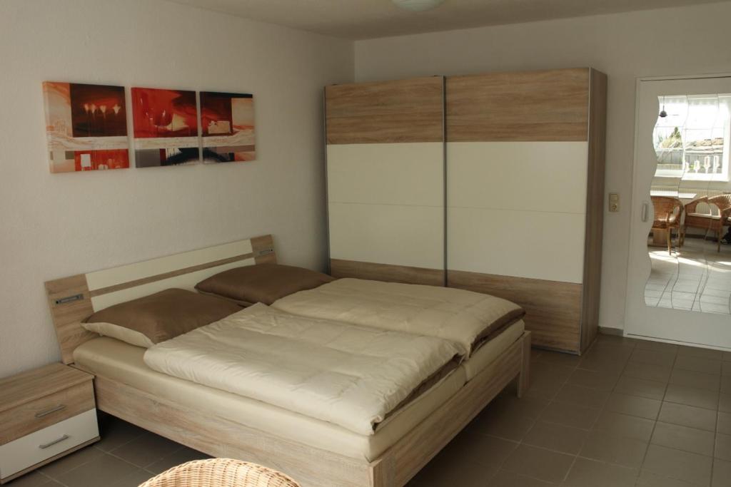 - une chambre avec un lit et une tête de lit en bois dans l'établissement Ferienwohnung Zur Trolle, à Erfurt
