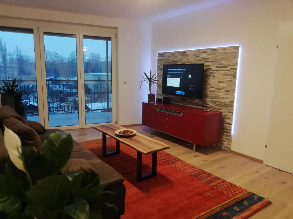 a living room with a couch and a tv at APARTMENT SCHLOSSBERGBLICK in Graz