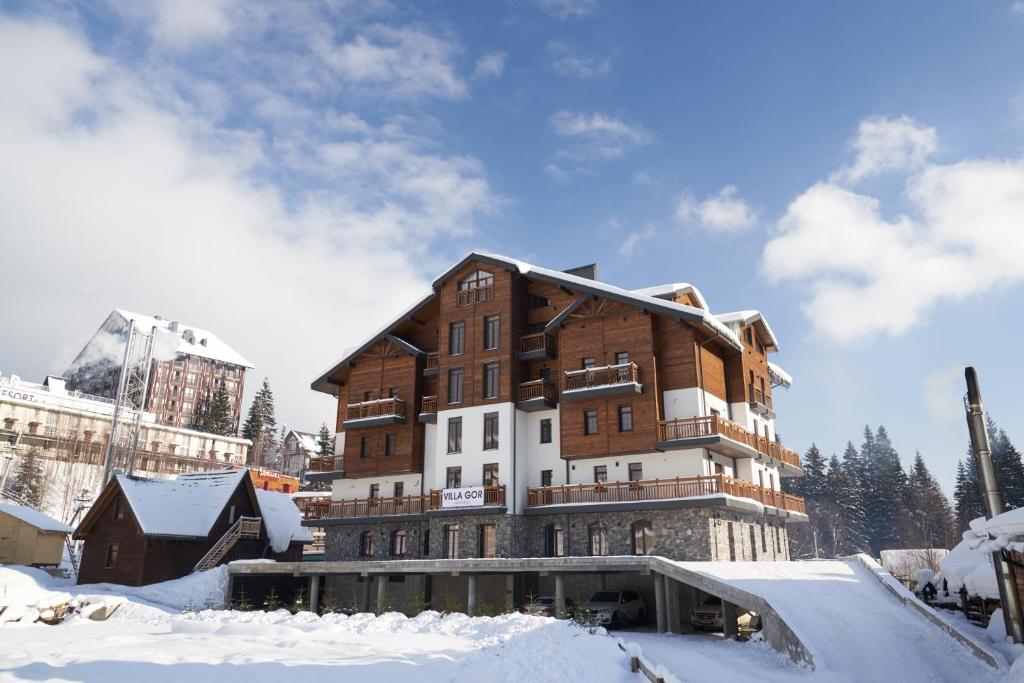 a large building with snow on the ground at Villa Gor Apartments in Bukovel