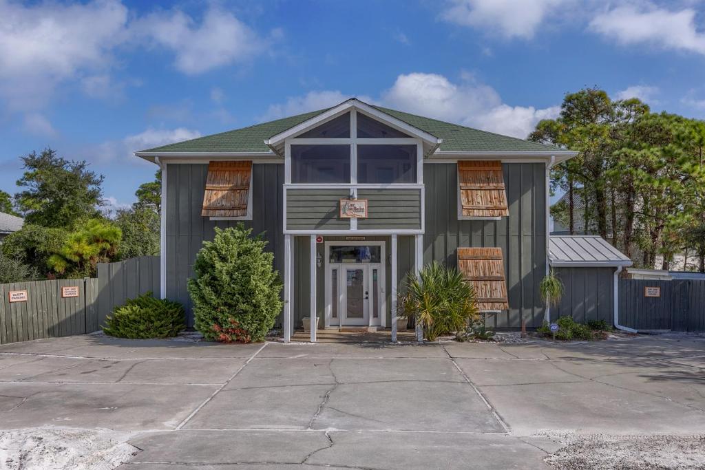 a gray house with a driveway in front of it at Cape San Blas Inn in Indian Pass