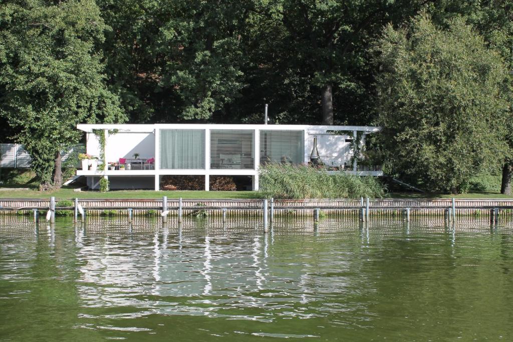 a house on a dock next to a body of water at Marina Hausboote und Seelodge in Berlin