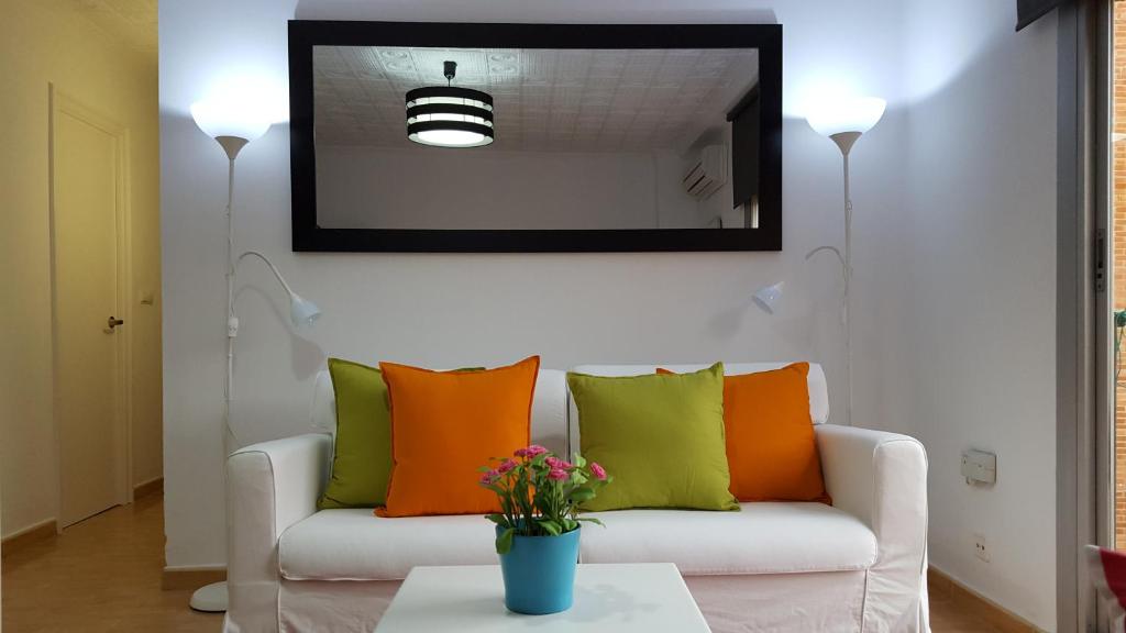 sala de estar con sofá y almohadas coloridas en Central Apartment in Valencia with WIFI + Parking. en Valencia