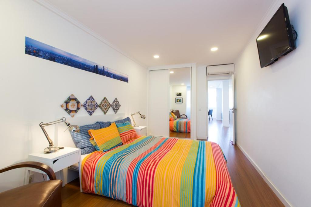 a bedroom with a colorful bed and a television at Cozy place in Lisbon 23 in Lisbon