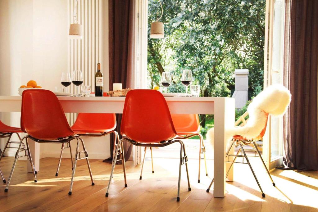 ヘルヌムにあるStrandhaus-Hoernumのダイニングルーム(赤い椅子、白いテーブル付)