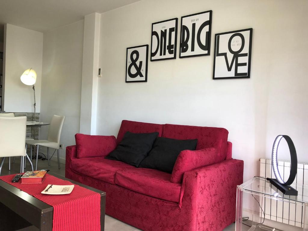 een woonkamer met een rode bank en een tafel bij Rent Apart Caballito in Buenos Aires