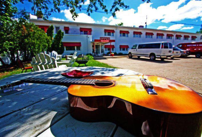 una guitarra sentada en una mesa frente a un edificio en Holiday Music Motel, en Sturgeon Bay