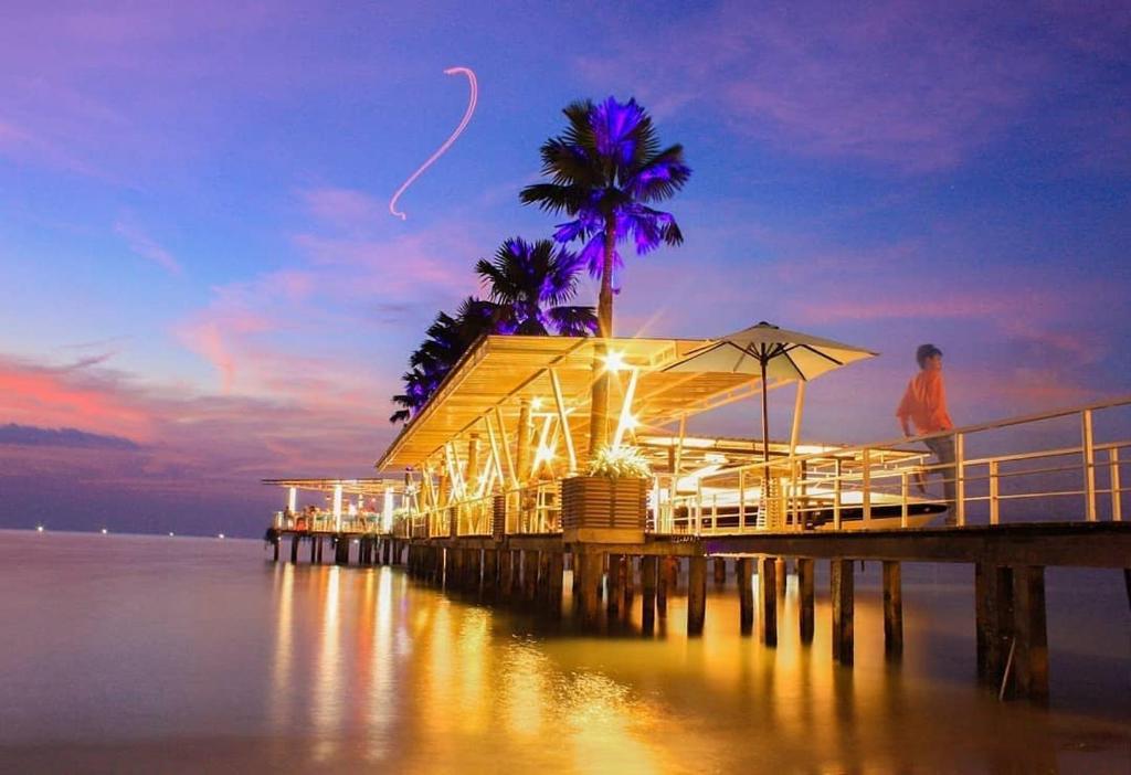 a man standing on a pier near the water at Ocean View Residence in Jepara