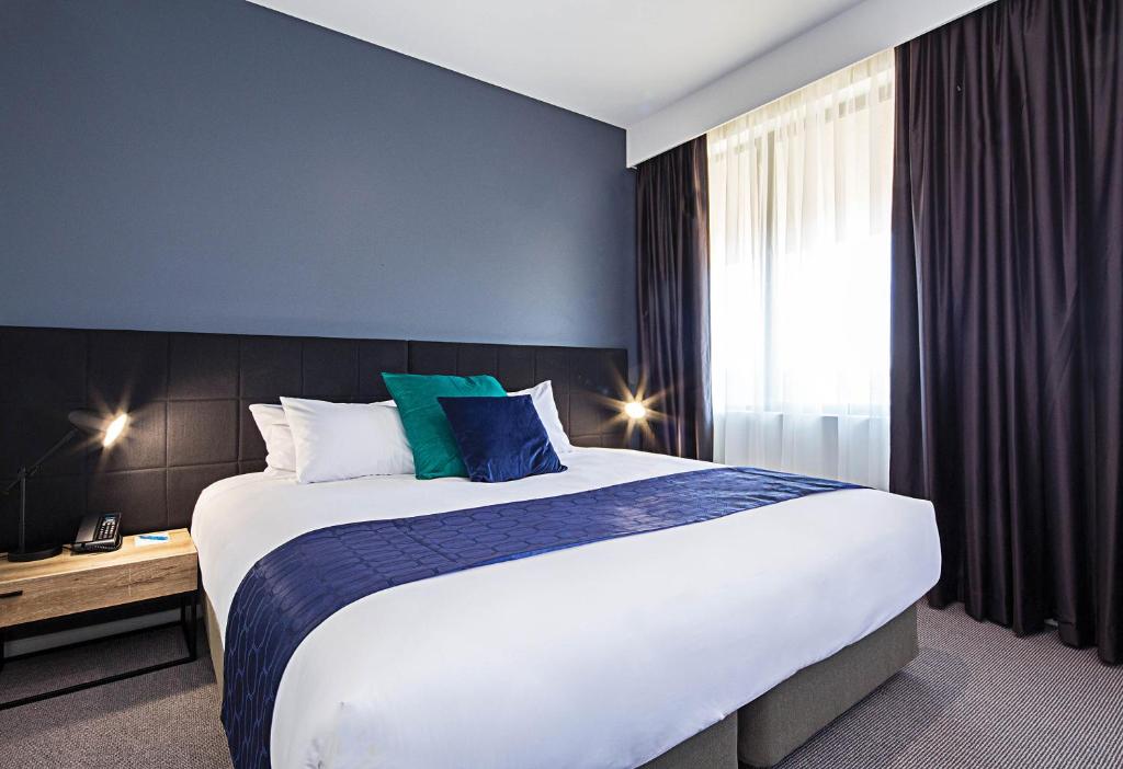 Postel nebo postele na pokoji v ubytování Mantra MacArthur Hotel