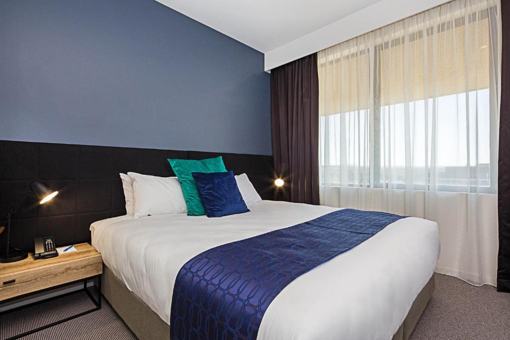 Postel nebo postele na pokoji v ubytování Mantra MacArthur Hotel