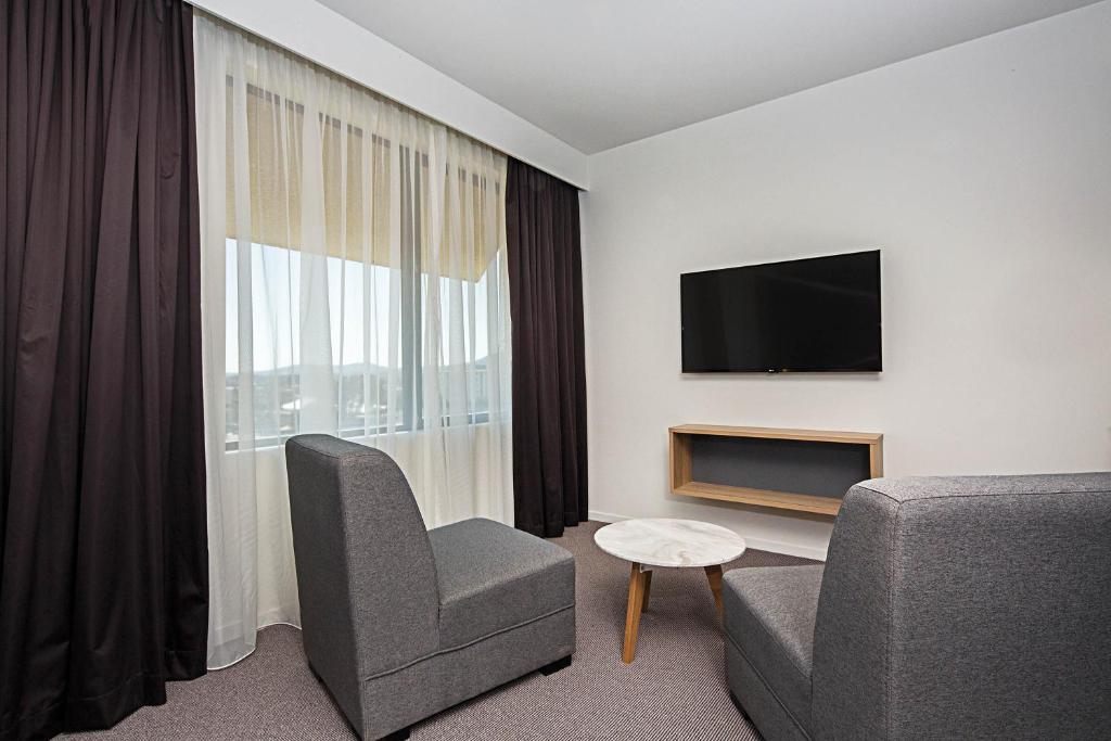 TV a/nebo společenská místnost v ubytování Mantra MacArthur Hotel