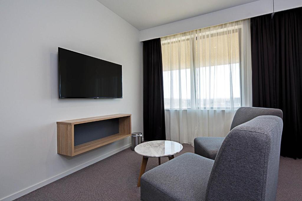 TV a/nebo společenská místnost v ubytování Mantra MacArthur Hotel