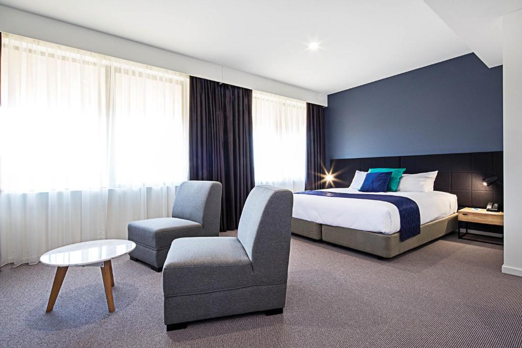 Postel nebo postele na pokoji v ubytování Mantra MacArthur Hotel