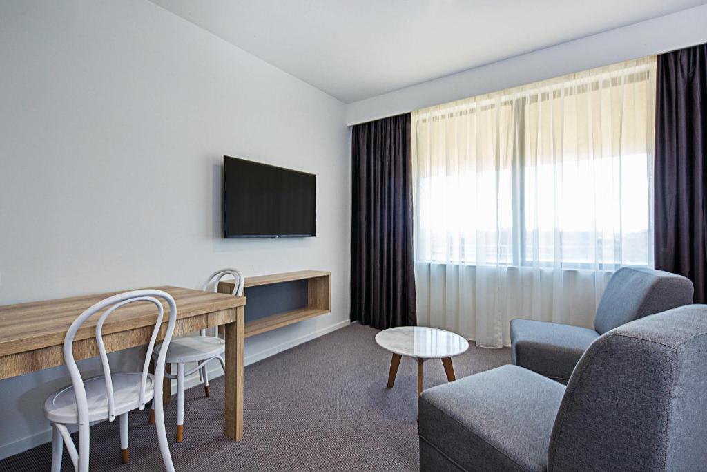 TV a/nebo společenská místnost v ubytování Mantra MacArthur Hotel