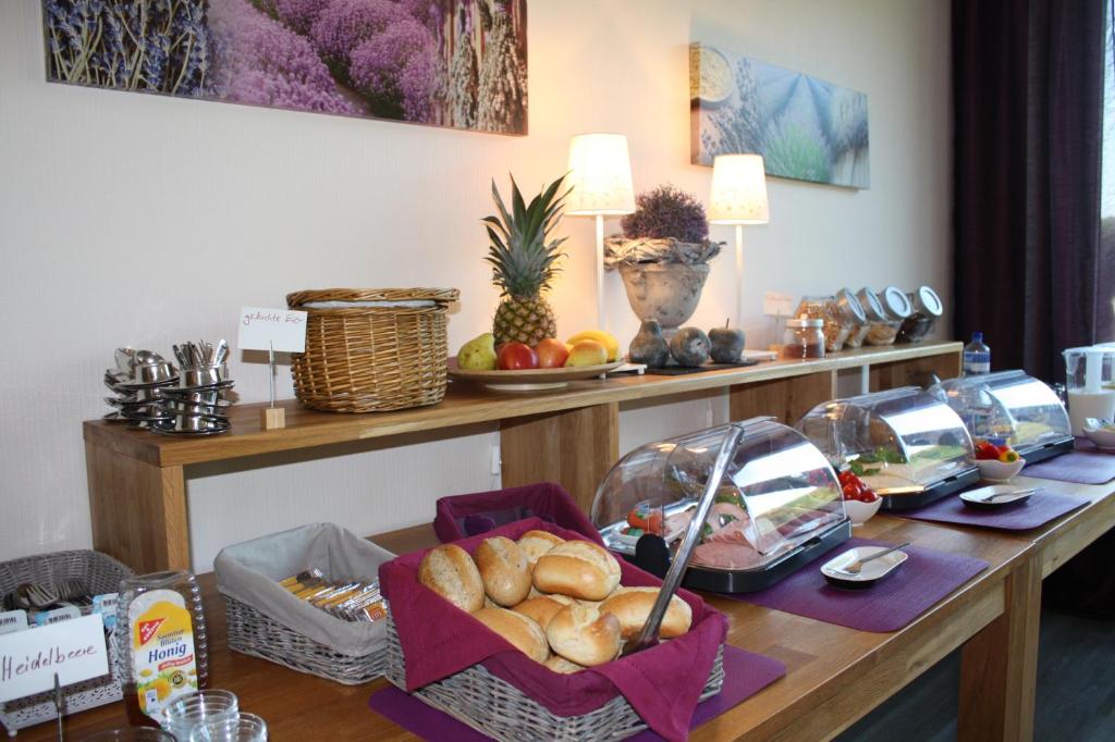 a table with bread and other items on it at Hotel am Siebenpfennigsknapp in Lünen