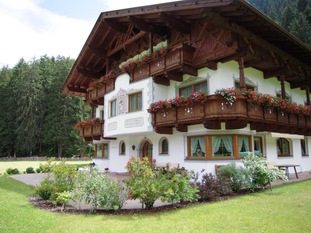 un edificio con cajas de flores en su lado en Pension Peter, en Neustift im Stubaital