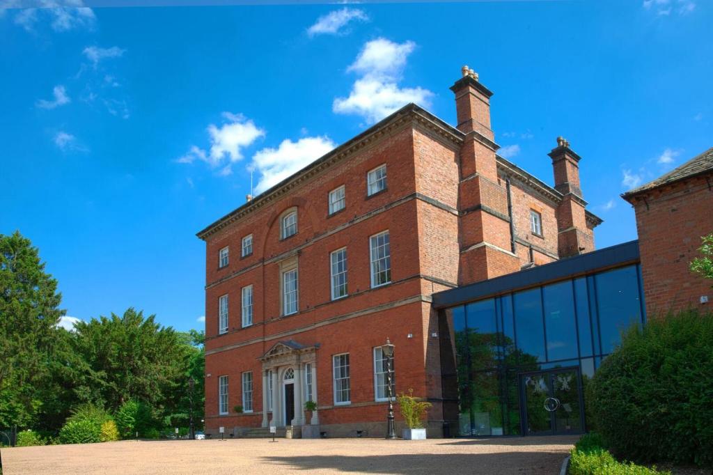 a brick building with two chimneys on top of it at Winstanley House in Leicester