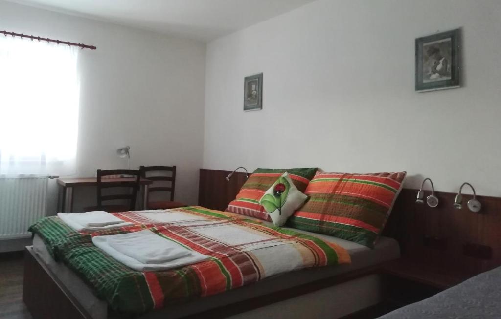1 dormitorio con 1 cama con mantas y almohadas en Motorest U Kola, en Prostějov