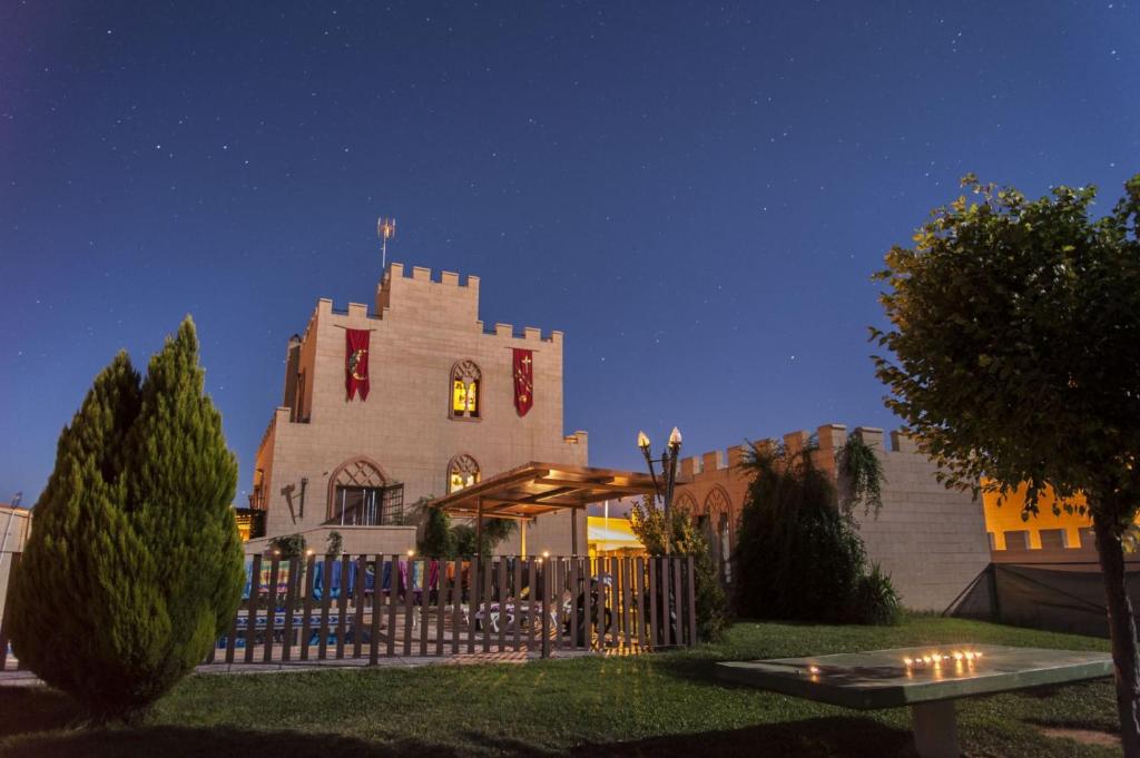 duży budynek z wieżą zegarową w nocy w obiekcie Casa Rural La Alcazaba w mieście El Robledo