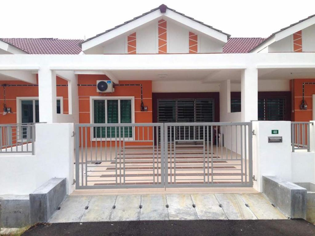 una casa de color naranja y blanco en NUHA HOMESTAY en Seri Iskandar