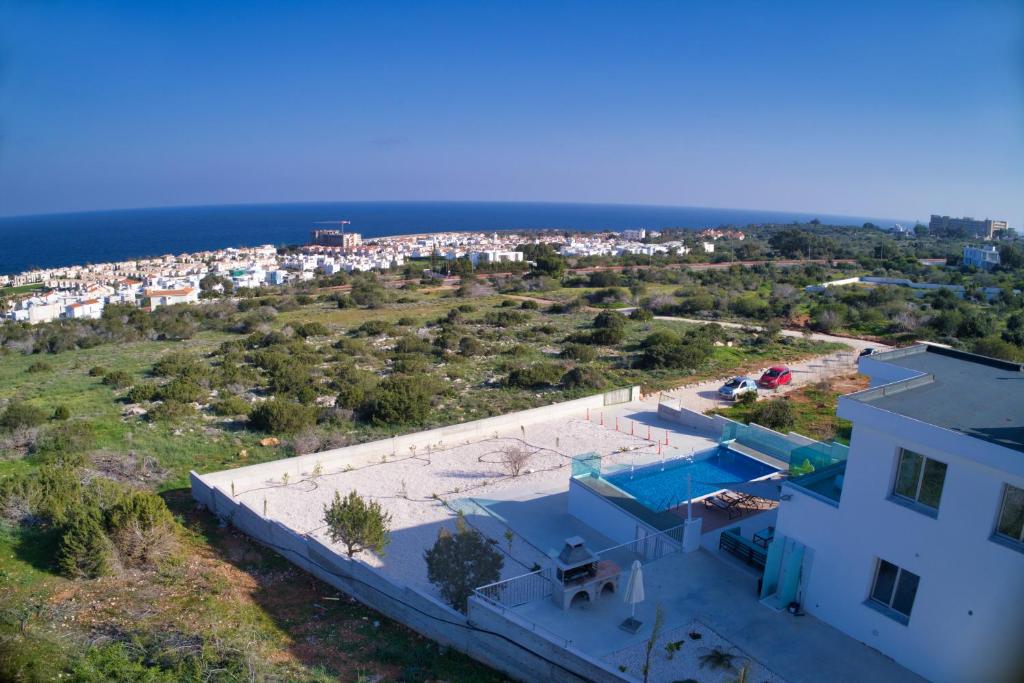 eine Luftansicht eines Hauses und des Ozeans in der Unterkunft Aetopetra Villa in Protaras