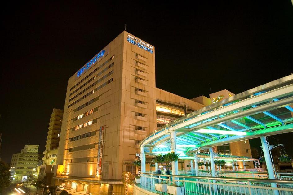 een groot hotelgebouw met een verlicht gebouw bij Meitetsu Toyota Hotel in Toyota