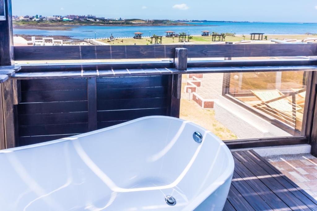 a bath tub on a balcony with a view of the beach at Malibu OceanView Homestay in Magong