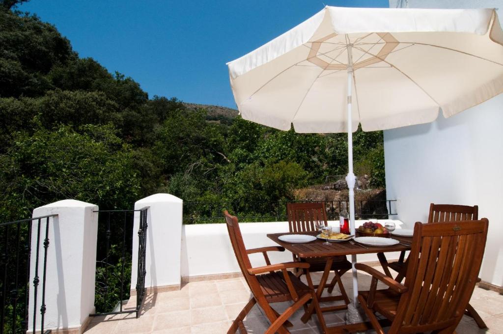 a table and chairs with an umbrella on a patio at La Panadería at Molino la Ratonera in Granada