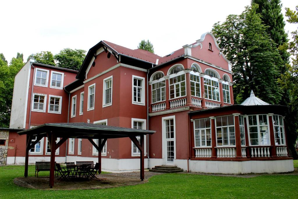 a large red building with a gazebo in front of it at BF Hotel in Balatonföldvár