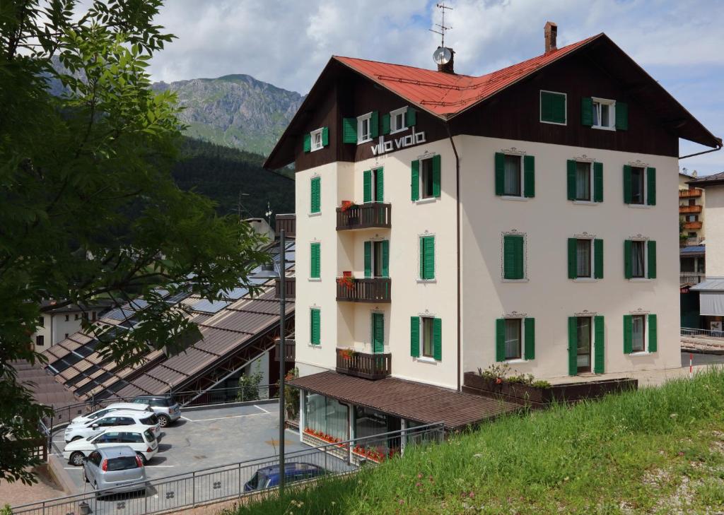 a large white building with a red roof at Residence Villa Viola in Andalo