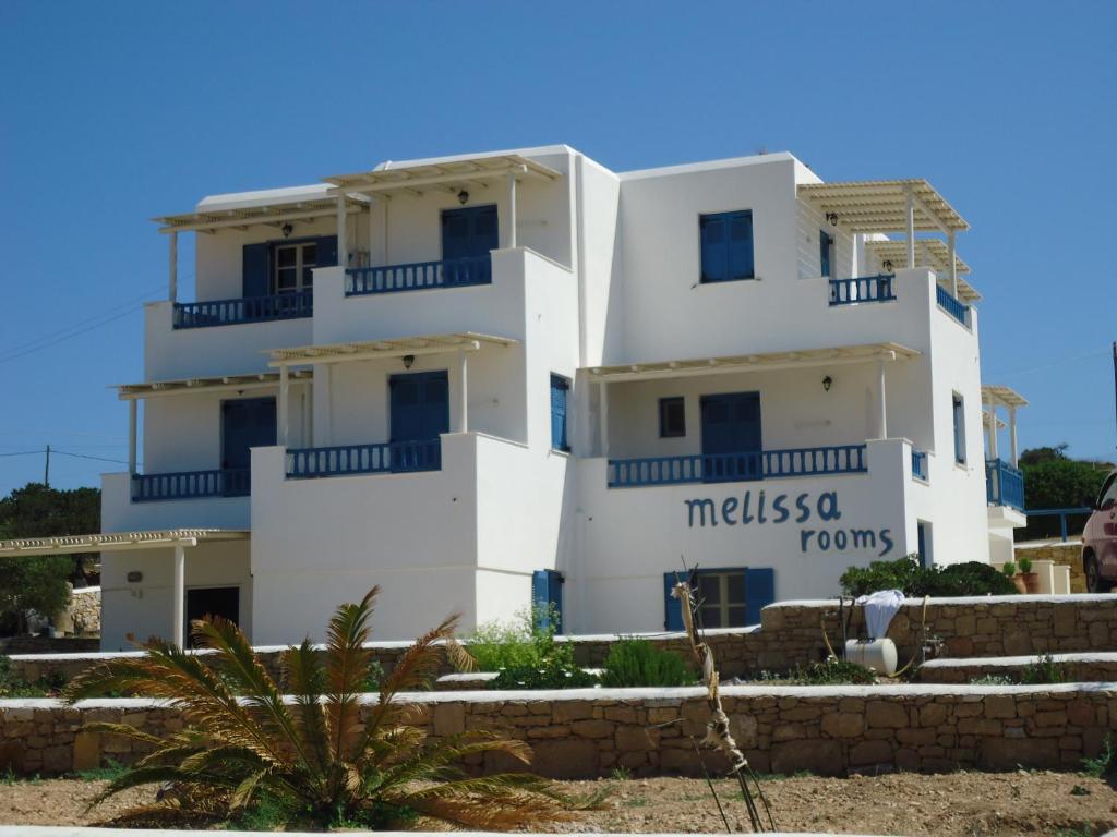 a white building with a sign on it at Melissa Rooms in Koufonisia