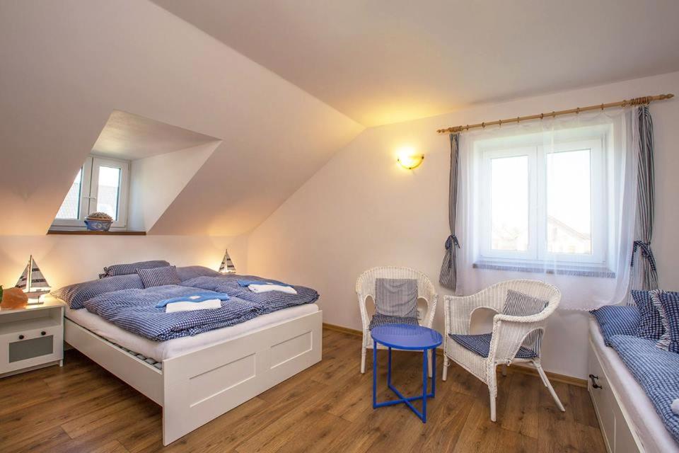 een slaapkamer met een bed en een tafel en stoelen bij Penzion Domanín in Třeboň