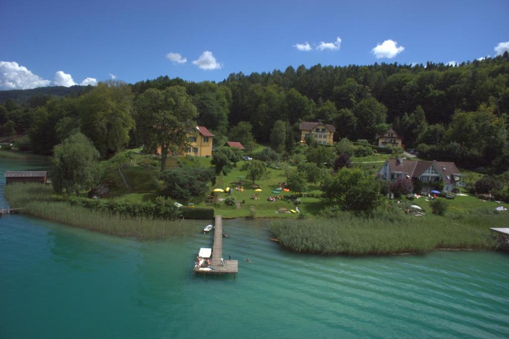 un petit bateau dans une rivière près d'un village dans l'établissement Pension Seevilla Annelies, à Maria Wörth