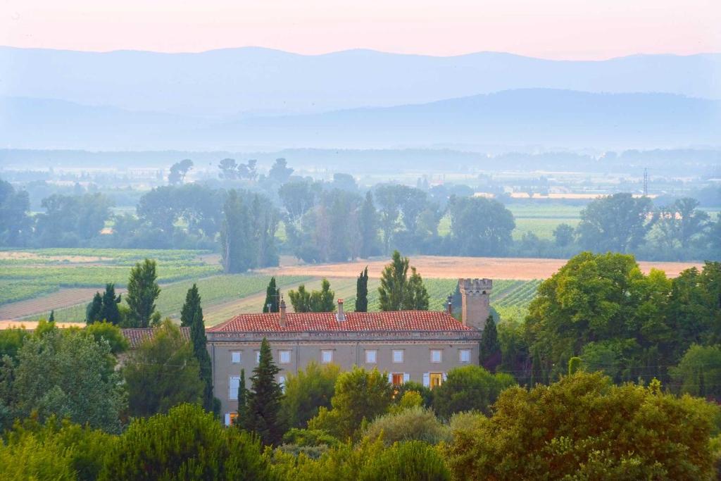 a building in the middle of a field with trees at Château de la Motte in Marcorignan