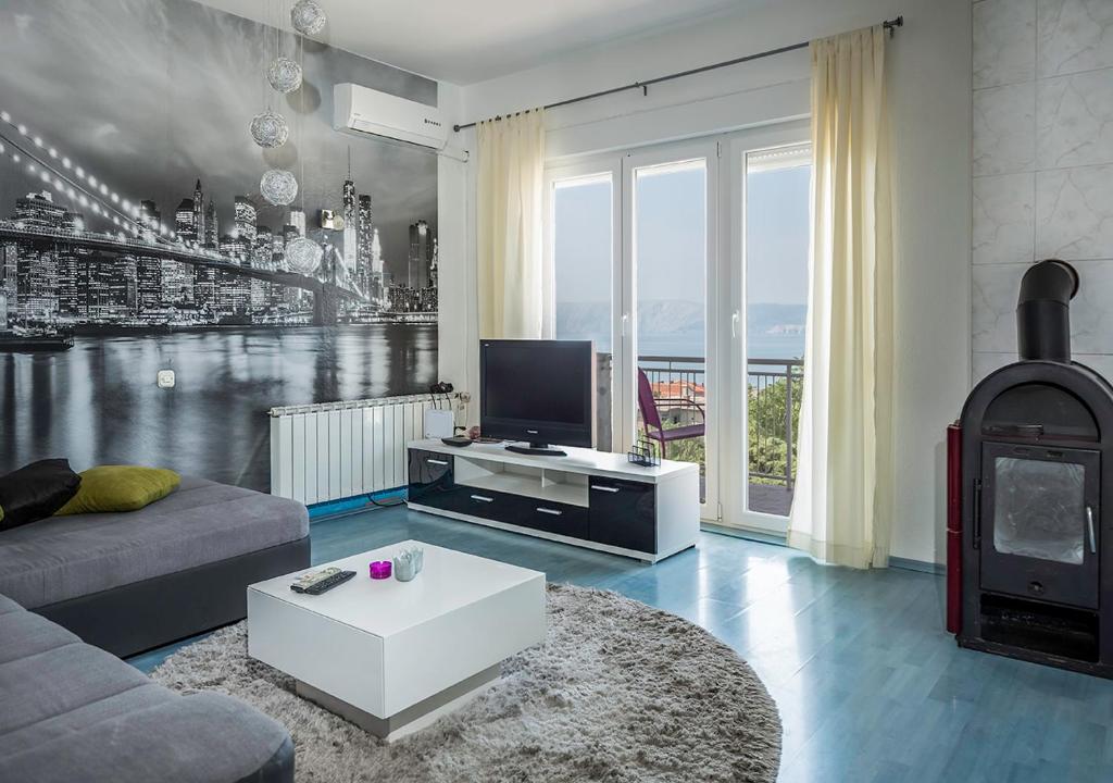 sala de estar con sofá, TV y chimenea en Apartments Tepavac, en Novi Vinodolski