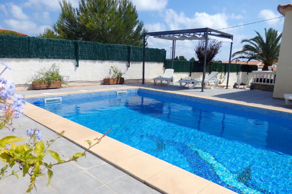 a swimming pool with blue water in a yard at MEDDAYS VILLA AMPARO in Miami Platja