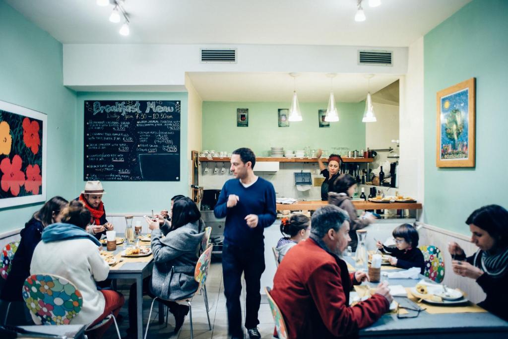 a group of people sitting at tables in a restaurant at The Beehive in Rome