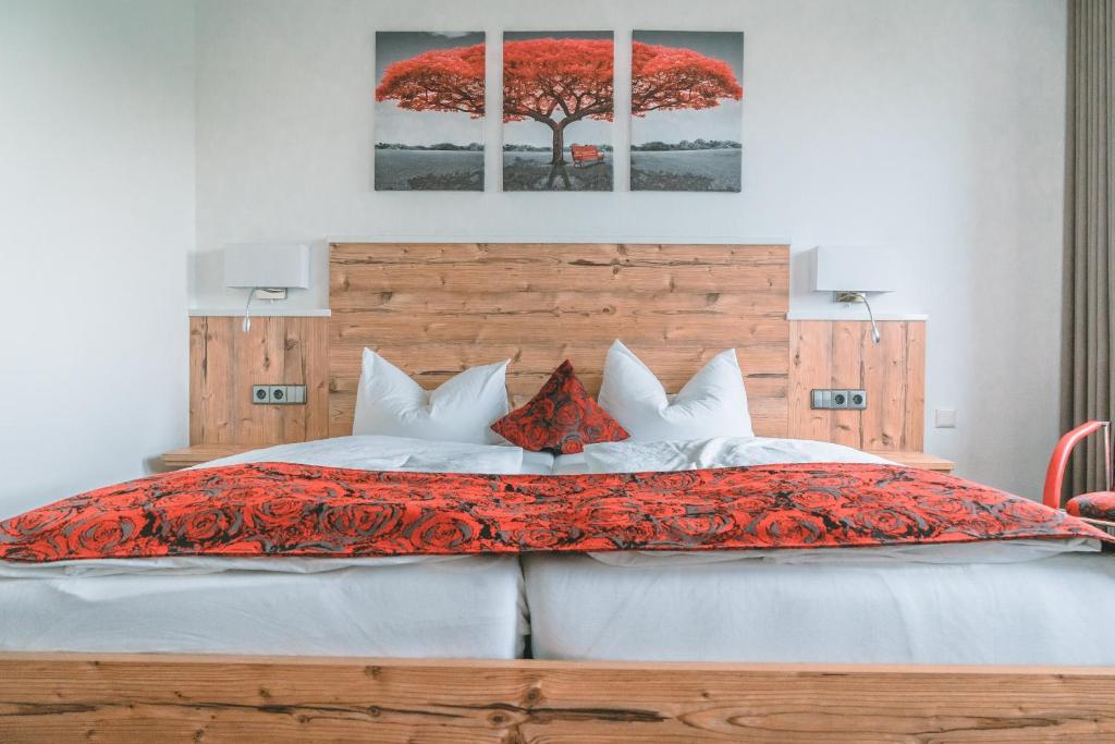 a bedroom with a bed with a red blanket at Hotel Sonne Garni in Bad Friedrichshall