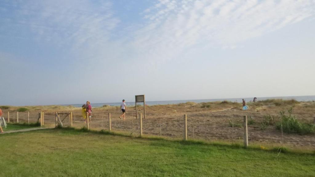 a group of people walking on the beach at Bungalows Bahia de la Plata in Zahara de los Atunes
