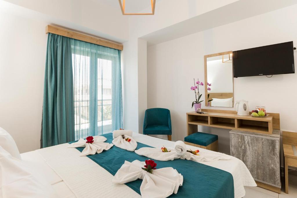 een hotelkamer met een bed met handdoeken erop bij Castell Hotel in Kissamos