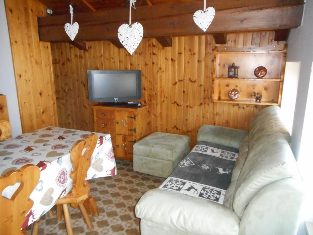 - un salon avec un canapé et une télévision dans l'établissement mansarda La Ruine, à Morgex