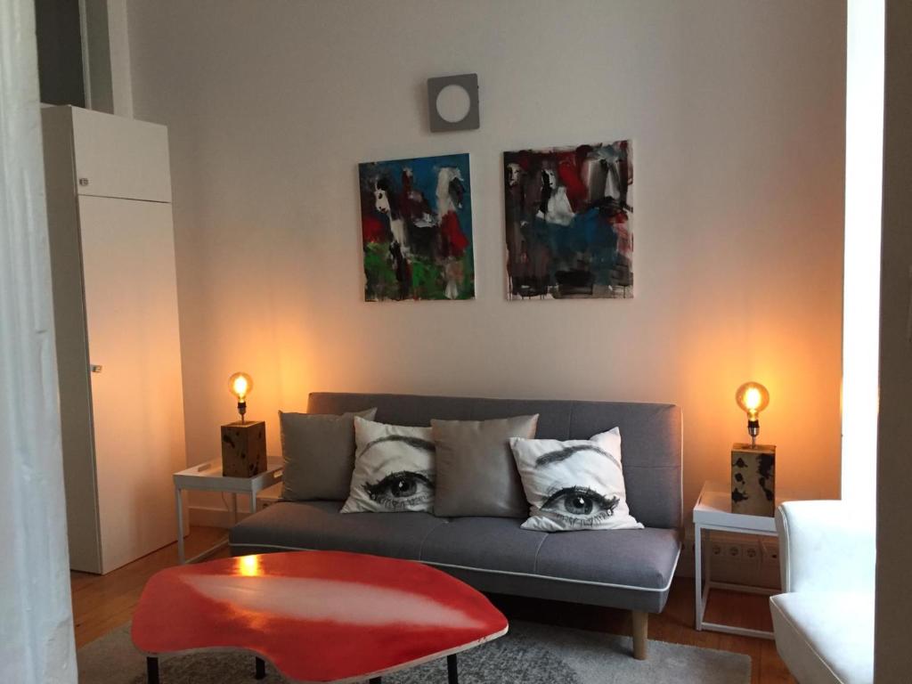 a living room with a couch with eyes on the pillows at Sapateiros Street 207 - City Center Apartment in Lisbon