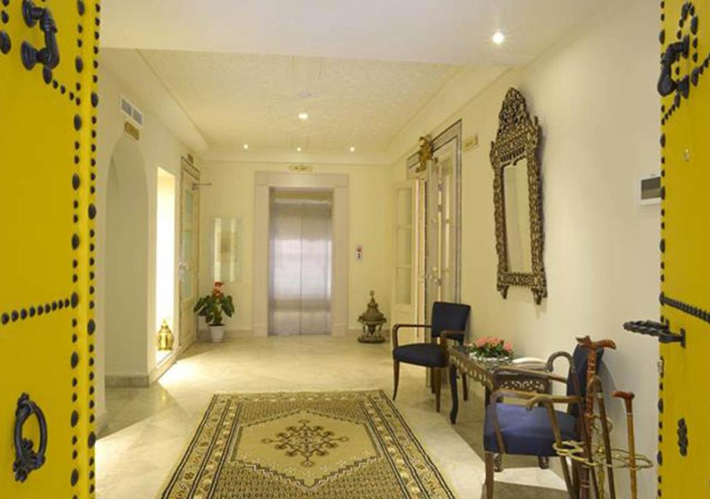 a living room with a table and chairs and a hallway at Dar ALOUINI in Kairouan