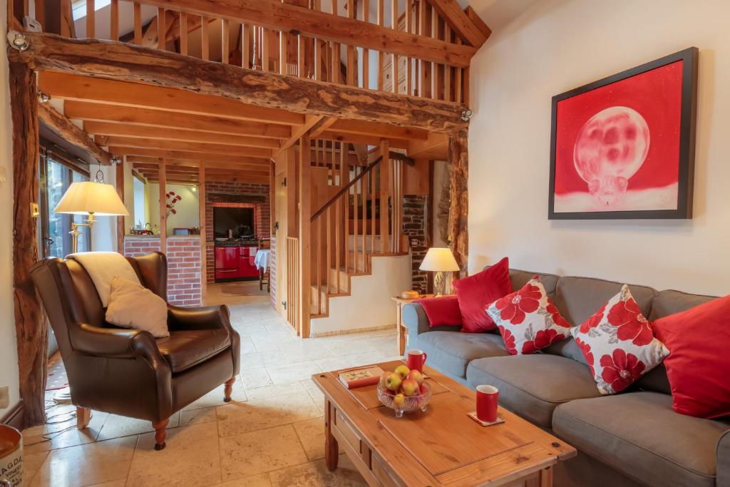 a living room with a couch and a table at WebberHillFarmCottages in Okehampton