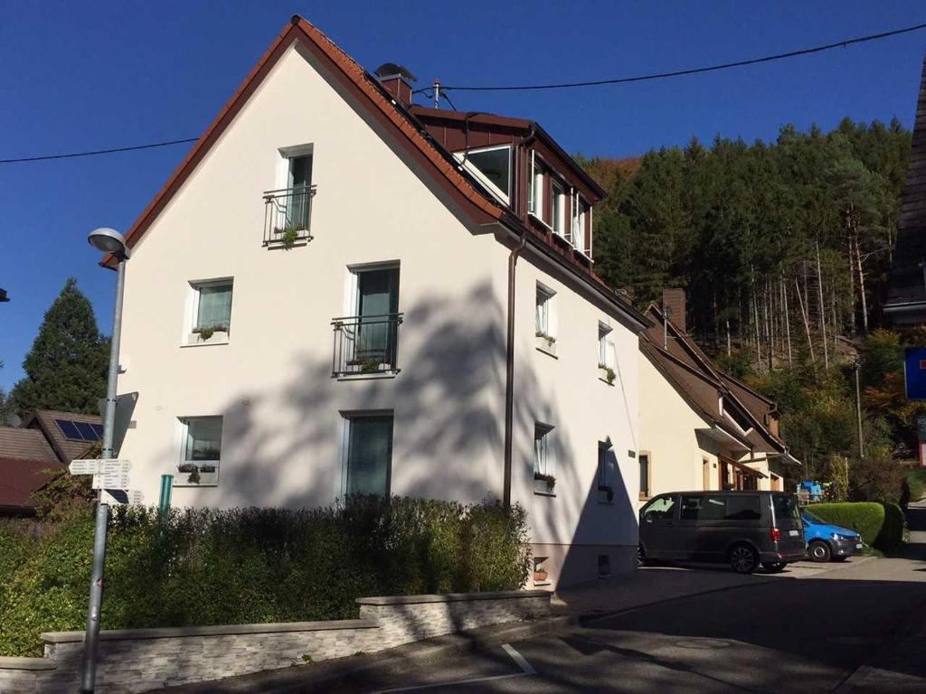 ein großes weißes Haus mit einem davor geparkt in der Unterkunft Ferienwohnung am Bannwald 1 in Freiburg im Breisgau