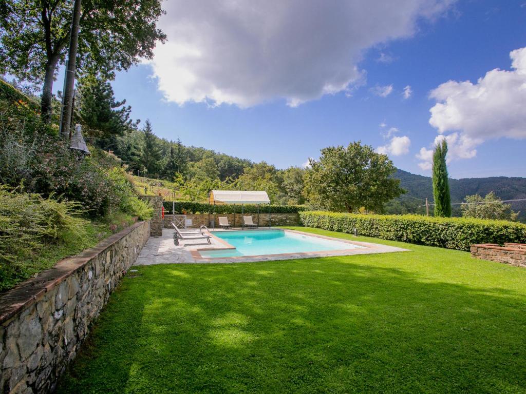 PiegaioにあるBelvilla by OYO Villa Ginestraの裏庭(スイミングプール、緑の芝生付)