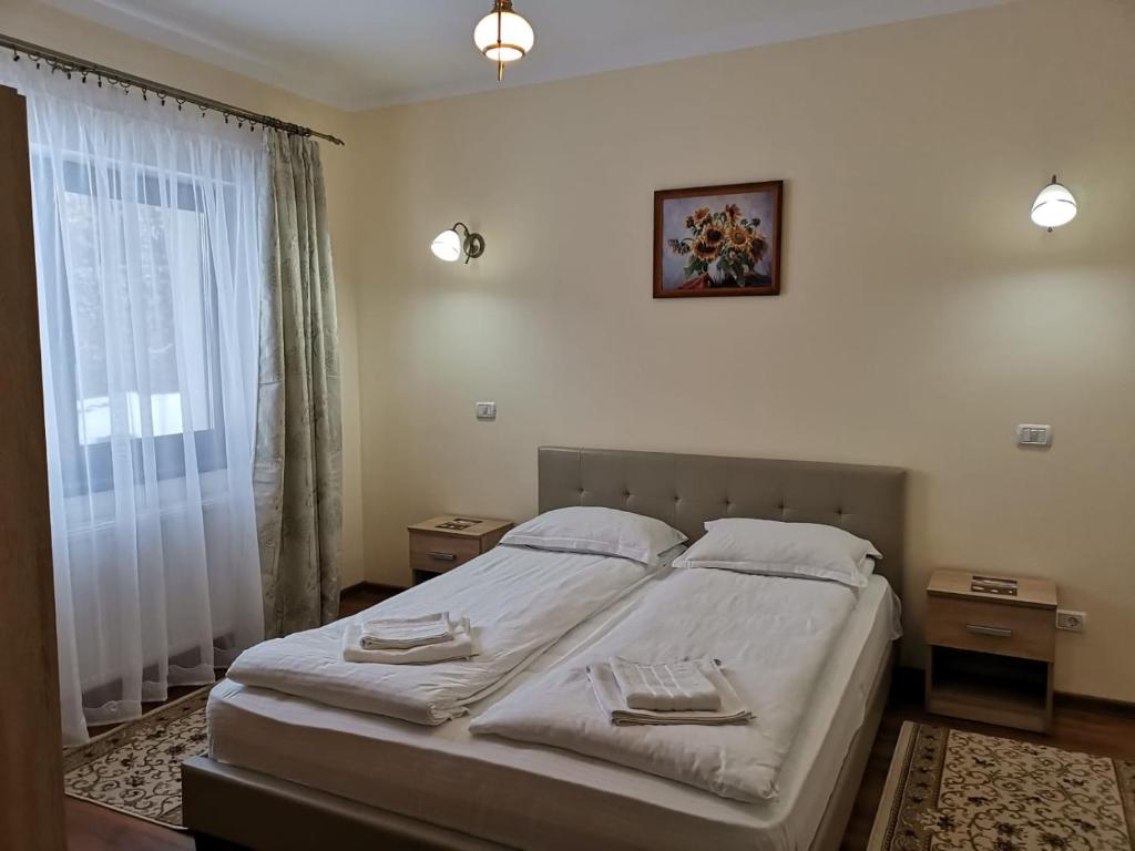 ein Schlafzimmer mit einem Bett mit zwei Handtüchern darauf in der Unterkunft Fantanita Craiesei in Făgăraş