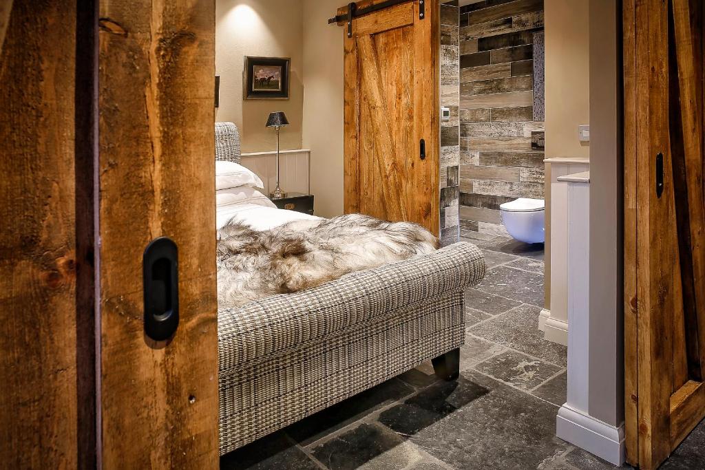 a bedroom with a bed and a couch in a room at Gileston Manor-Self catering in Saint Athans