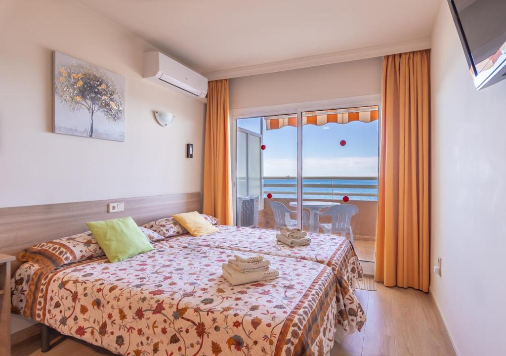 een slaapkamer met een bed en uitzicht op de oceaan bij Stellamar - Paseo Maritimo in Fuengirola