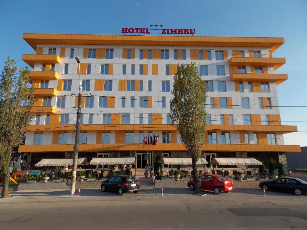a hotel with cars parked in front of a building at Hotel Zimbru in Iaşi